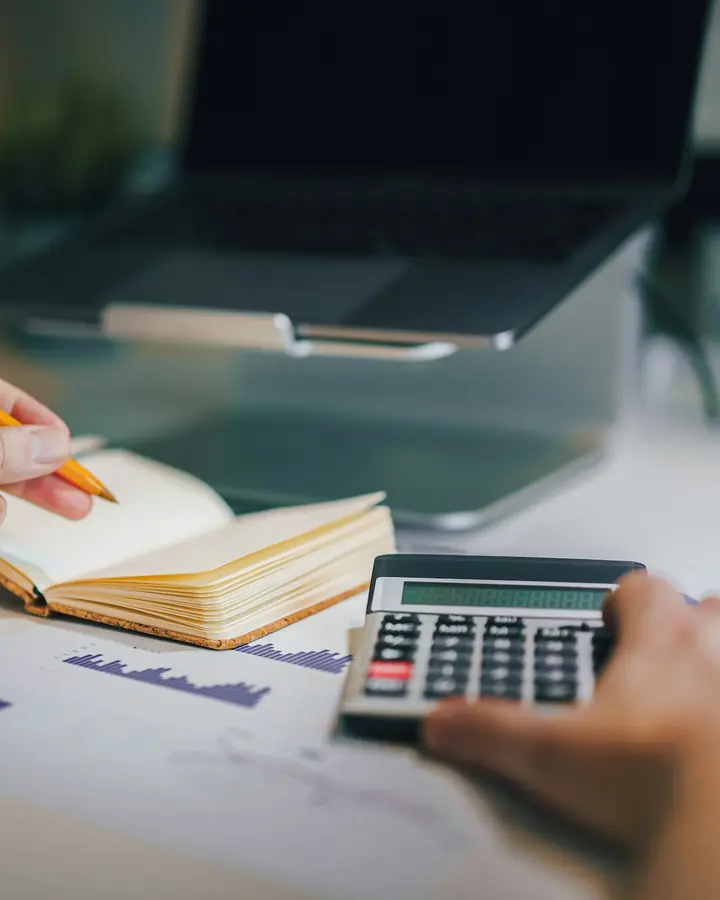 Mesa de escritório com calculadora e anotações